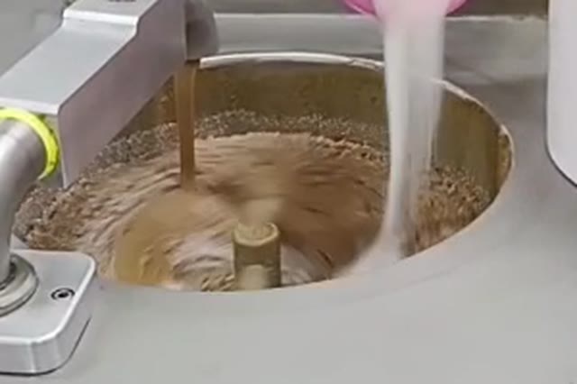 Chocolate ball mill refining chocolate inside the stainless steel vessel around the central agitator